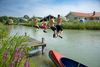 Kinder springen vom Steg in den See im Nordseebad Otterndorf