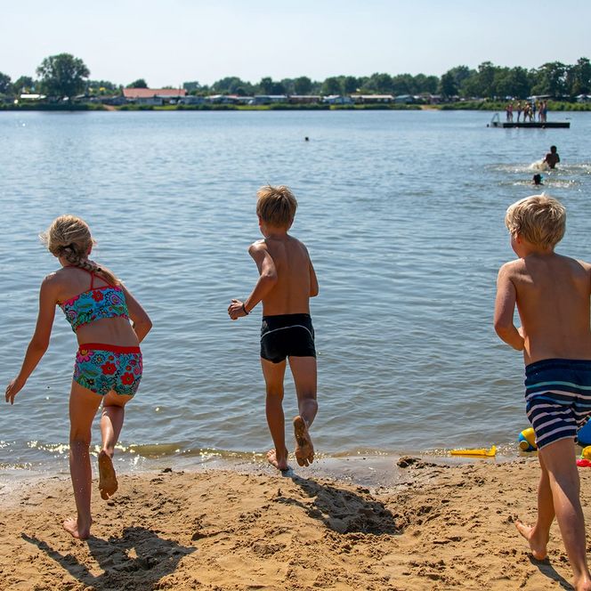Kinder laufen in den Badesee im Nordseebad Otterndorf