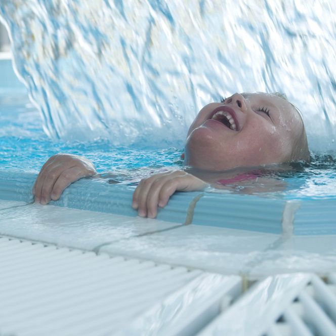 Sole-Therme Otterndorf Kind unter Wasserfall im Spaßbecken