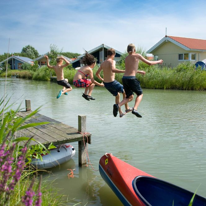 Kinder springen vom Steg in den See im Nordseebad Otterndorf