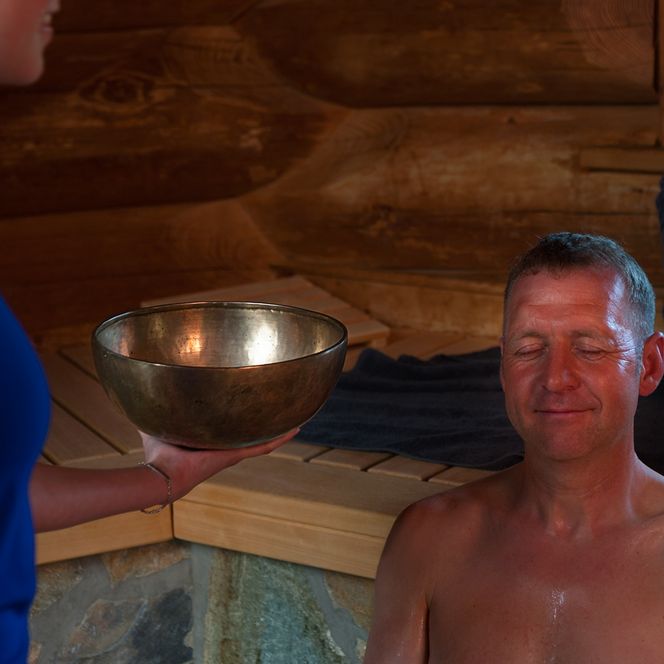 Schwimmeisterin mit Gästen und Klangschale in der Großen Außensauna der Sole-Therme
