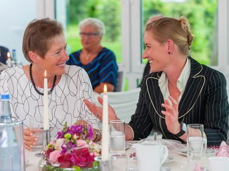 Zwei Frauen unterhalten sich am Tisch